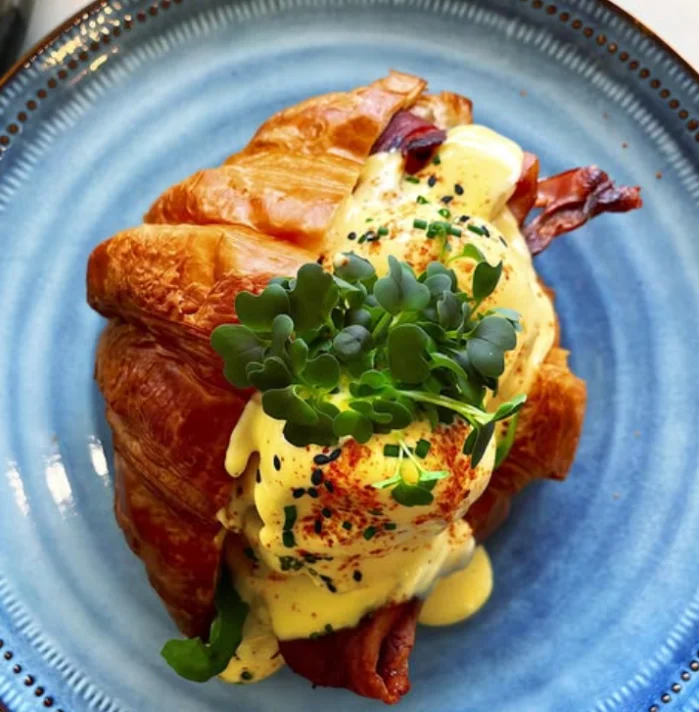 French Benny Croissant — croissant filled with poached eggs, bacon and house hollandaise at PointBreak Cafe, Coolangatta